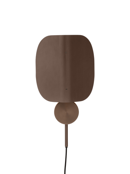 Front view of the Wing Wall Lamp in bronzed aluminium. The lamp is turned on, highlighting its distinctive folded shade.