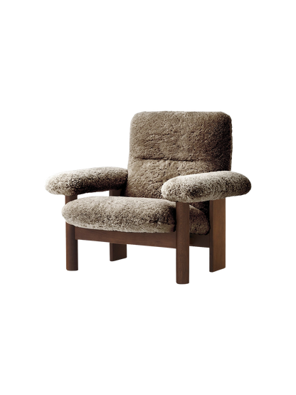 The Brasilia Lounge Chair in brown sheepskin. It has a high back, exaggerated armrests, and a sturdy dark wooden frame.