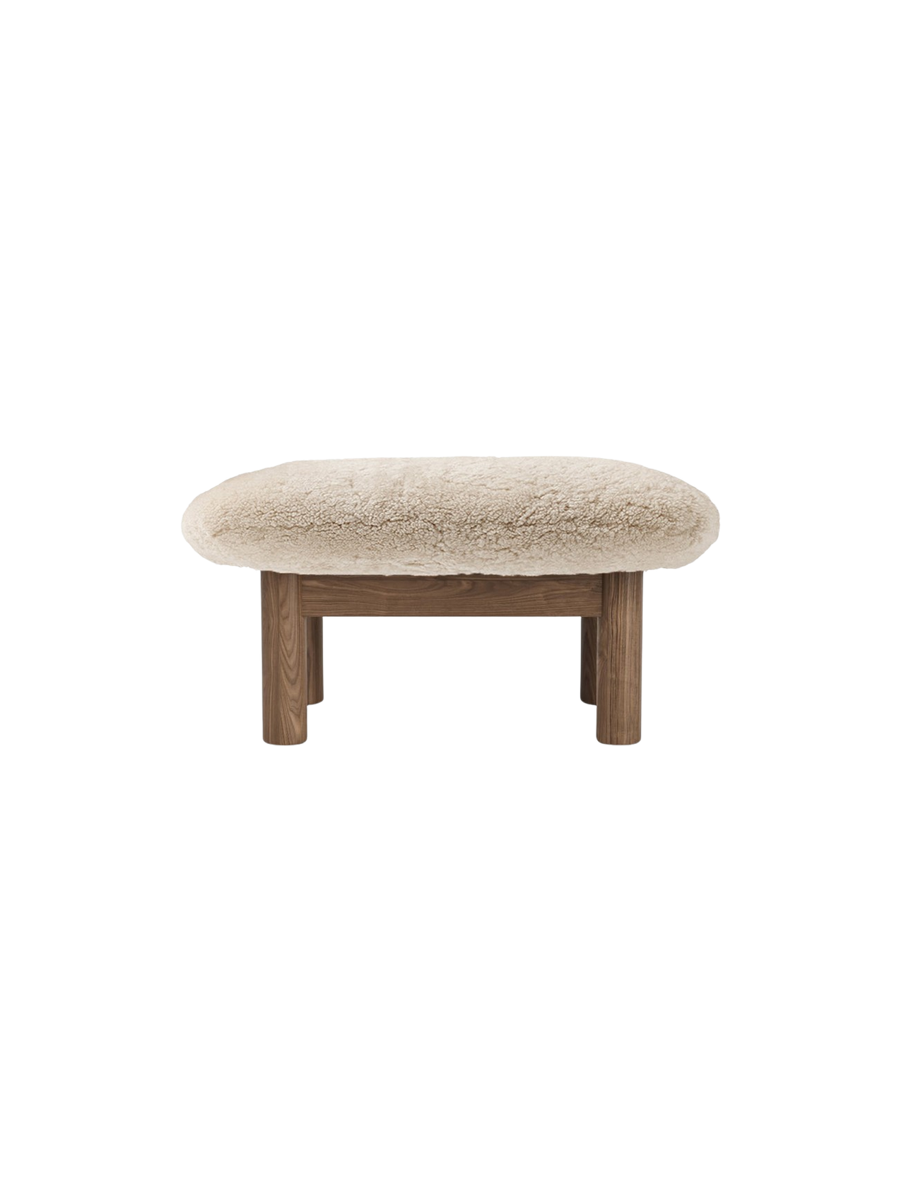 Front view of the Brasilia Ottoman, Sheepskin, featuring a plush, off-white cushion and four robust, cylindrical wooden legs.
