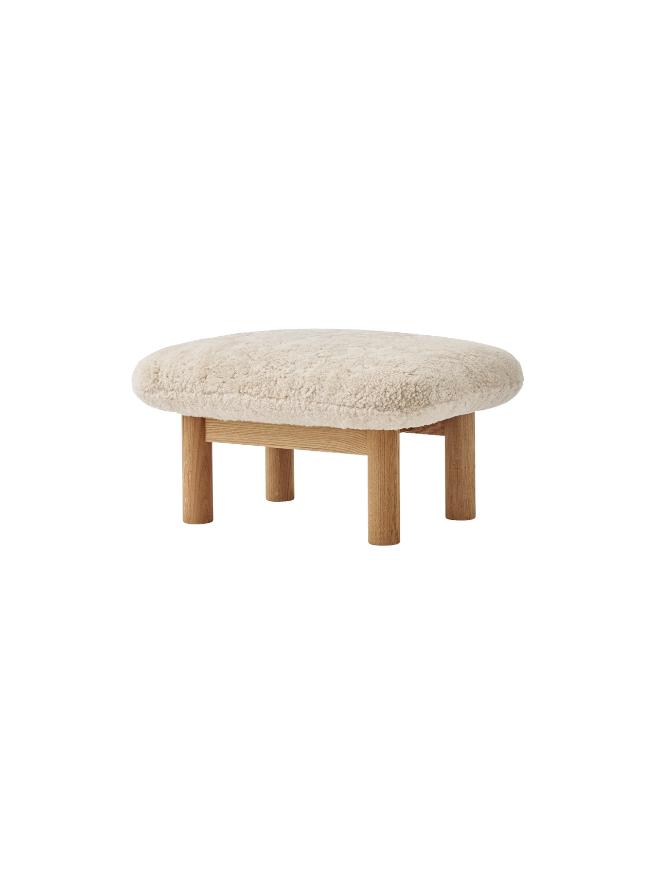 Angled view of the Brasilia Ottoman with a plush, off-white sheepskin cushion and four cylindrical legs in natural oak.