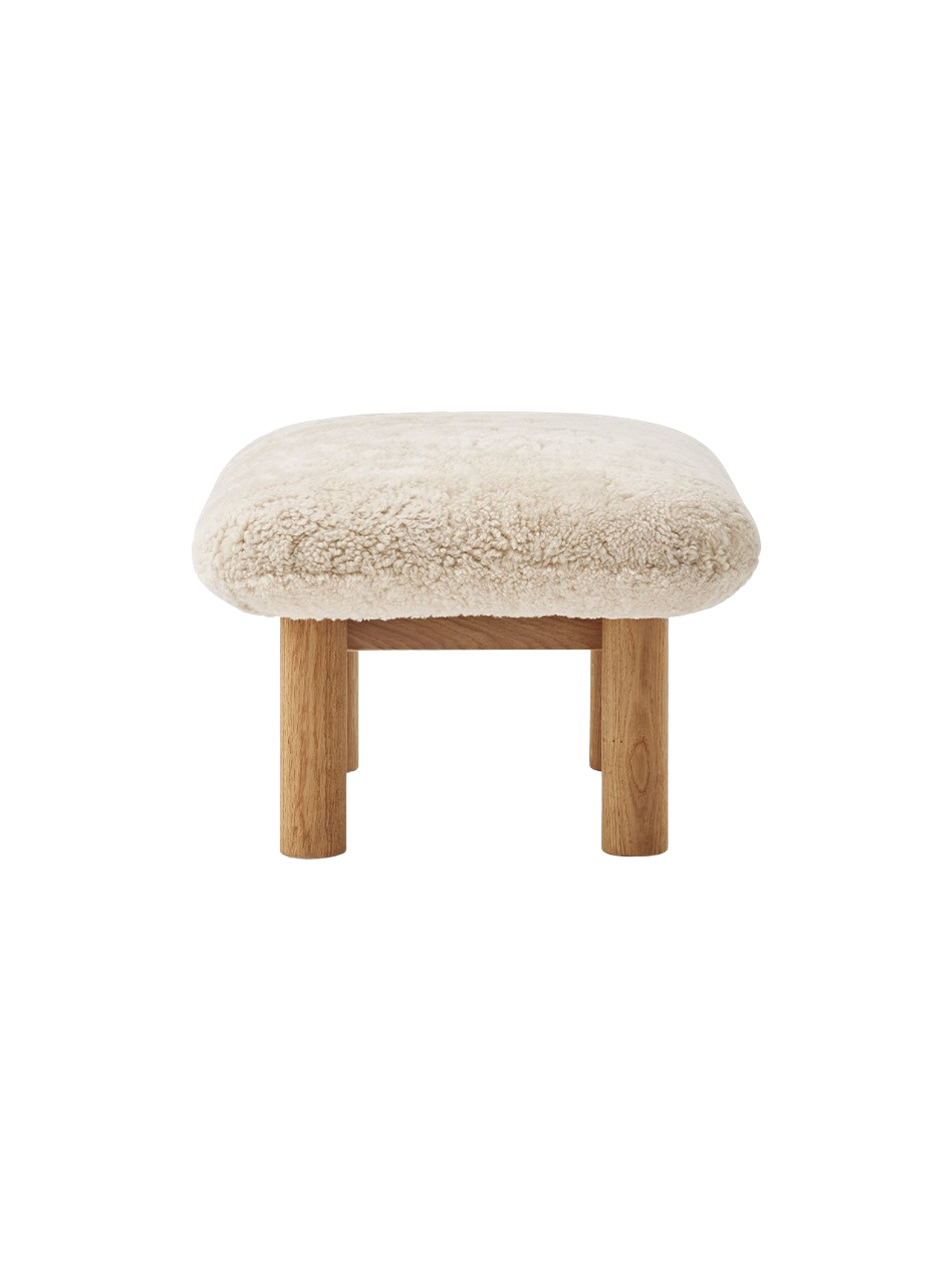 Side view of the Brasilia Ottoman, featuring a Sheepskin Nature cushion on a natural oak frame with robust cylindrical legs.