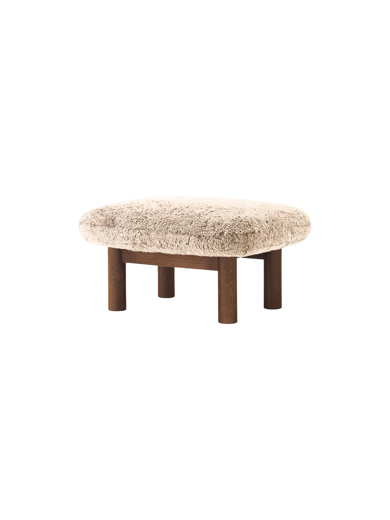 Brasilia Ottoman with a plush Sheepskin Root cushion and four robust, cylindrical legs in dark stained oak, at an angle.