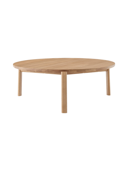 Front view of the Passage Lounge Table in natural oak. The low, round table has a solid wood top and three sturdy legs.