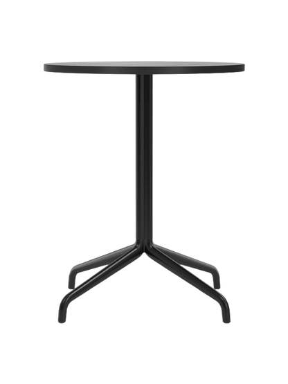 A front view of the Harbour Column Dining Table with a round black oak top and black star base, on a black background.