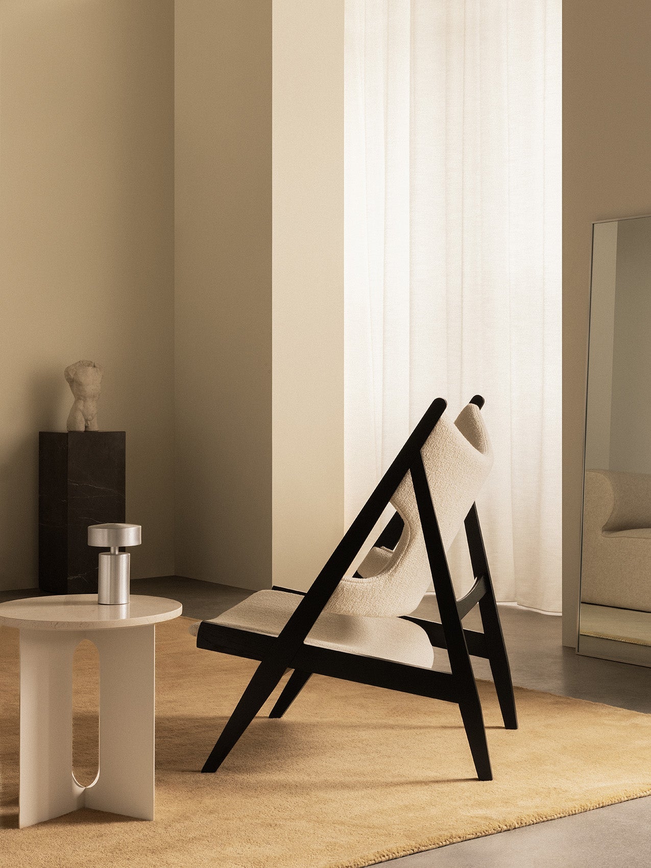Side view of the Knitting Lounge Chair in black oak with the Androgyne Side Table, Column Table Lamp, and Plinth Pedestal.