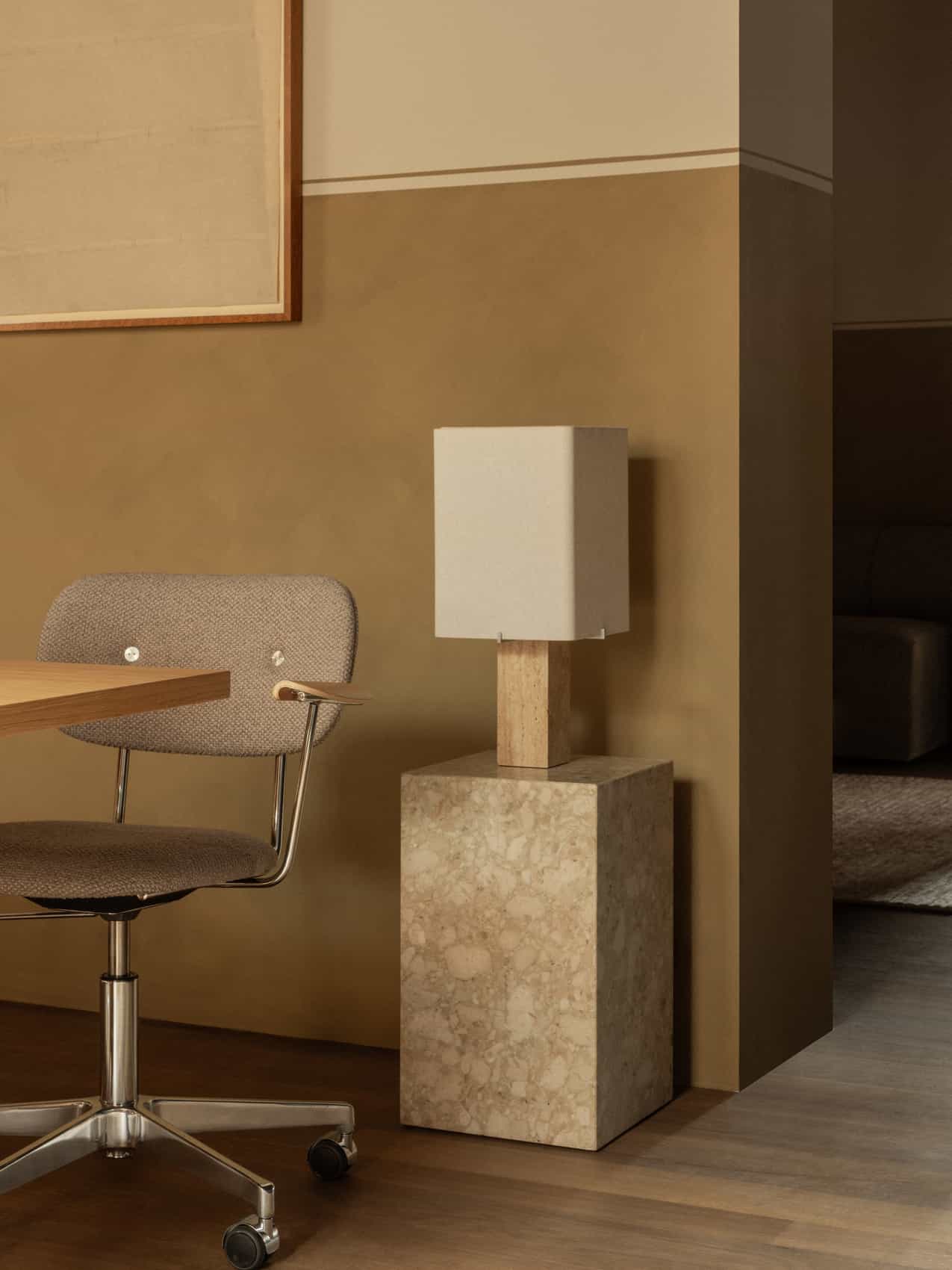 The Nonna Table Lamp on a Plinth Tall illuminates an office corner, with a grey Co Task Chair pulled up to a wooden desk.