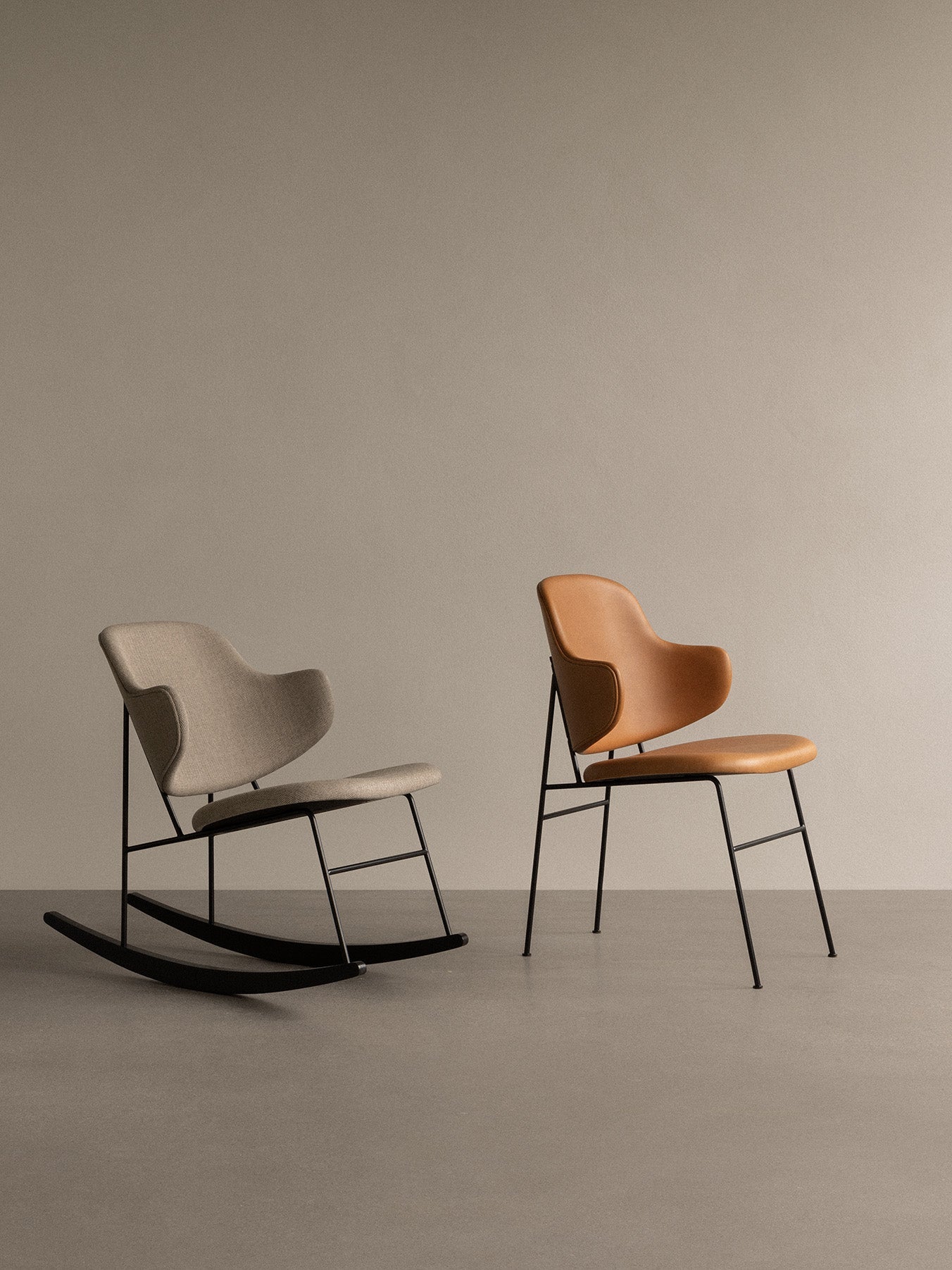 A light grey fabric Penguin Rocking Chair next to a tan leather Penguin Dining Chair, both with black frames.