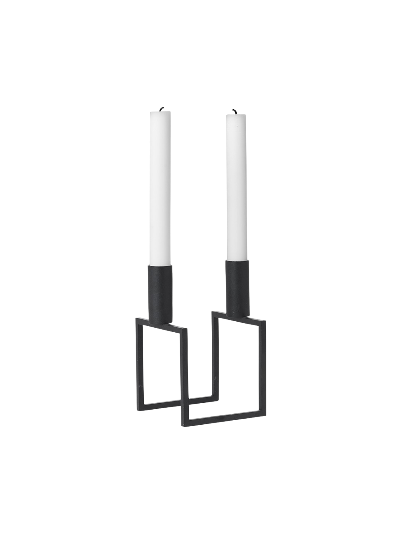 A black, geometric Kubus Line candle holder with two tall white candles, viewed from an angle against a black background.