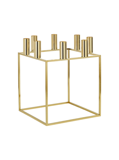 The gold-plated Kubus 8 candle holder, shown from an angle. It has a square, minimalist frame with 8 candle sockets on top.