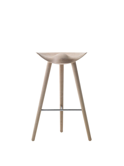 The ML 42 Bar Stool in soap-treated oak, viewed from the front, with a sculptural seat, three legs, and steel footrest.