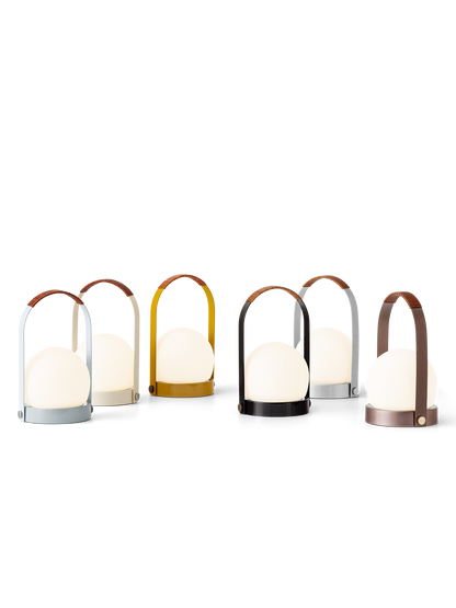 Carrie Portable Lamps in a range of finishes featuring glowing opal glass shades and leather-wrapped handles.