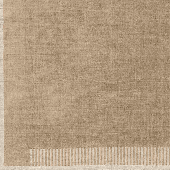 A close-up detail of the corner of the Duomo Rug in Limestone Beige, highlighting its woven texture and striped border.