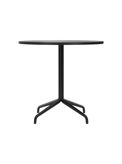 A front-on photograph of the Harbour Column Dining Table, featuring a round top in black oak and a slender, black starbase.