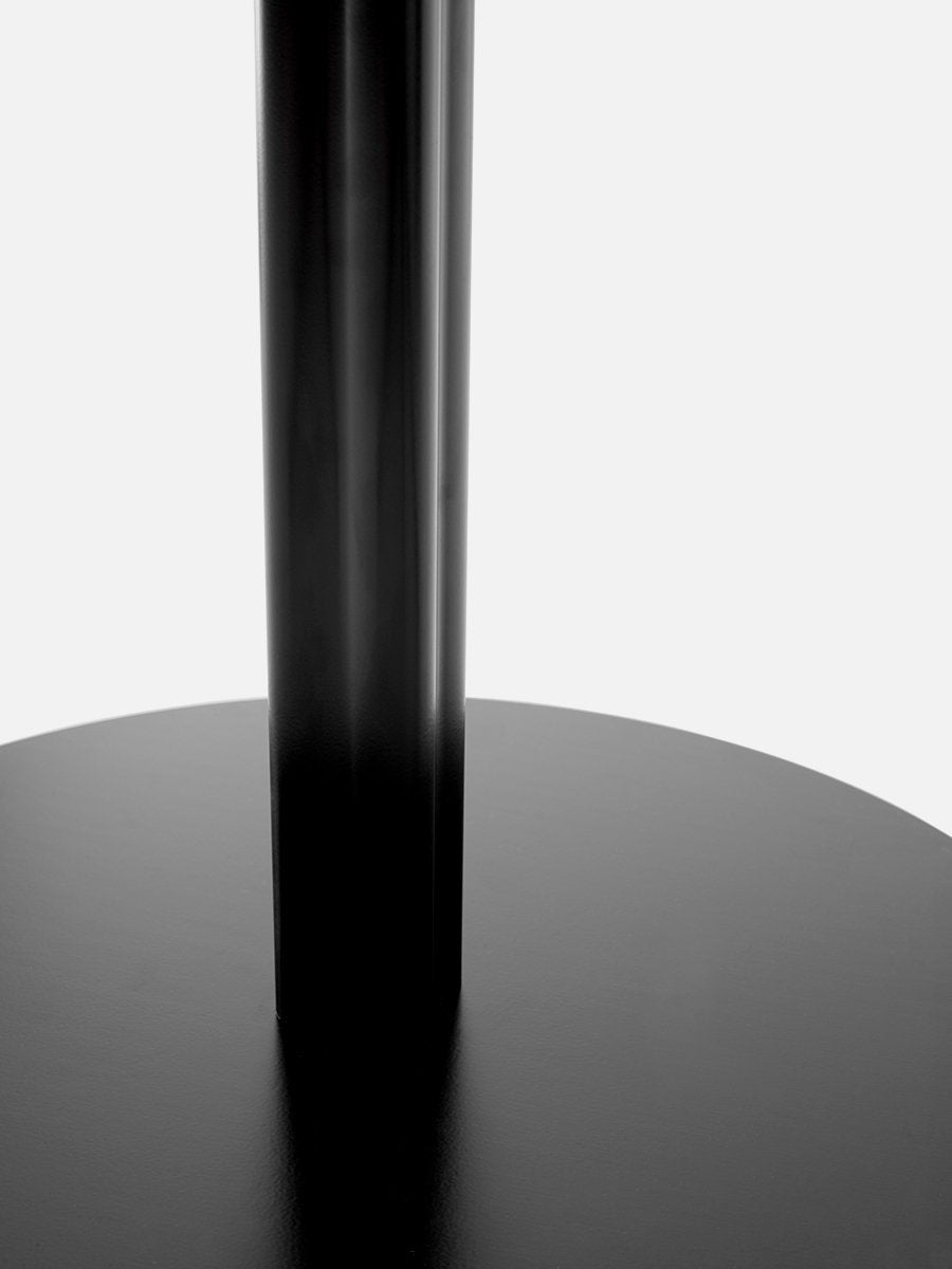 A close-up shot of the base of the black Harbour Column Table, highlighting the fluted column and the flat, circular base.