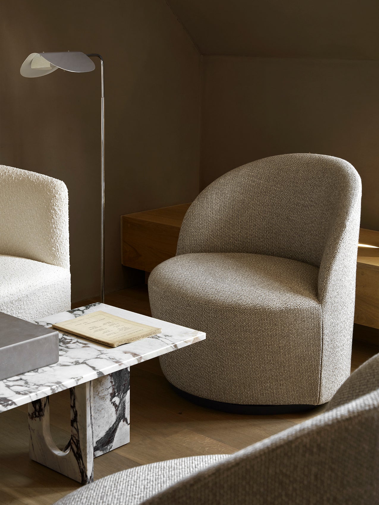 A cosy living room featuring the Wing Floor Lamp, a Tearoom Lounge Chair, and an Androgyne Lounge Table with a marble top.