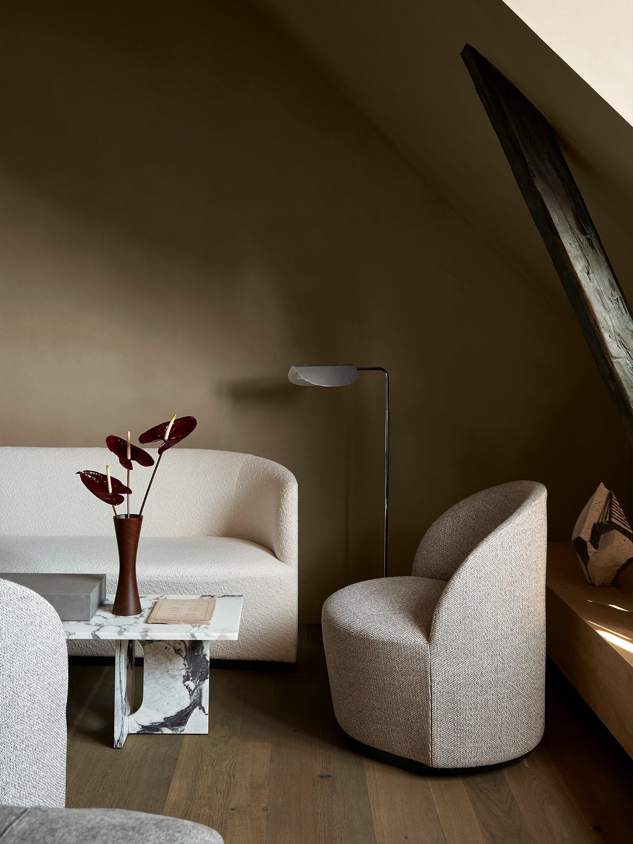Tearoom Lounge Chair in a dimly lit room with a Tearoom Sofa, Androgyne marble lounge table and a Wing Floor Lamp.