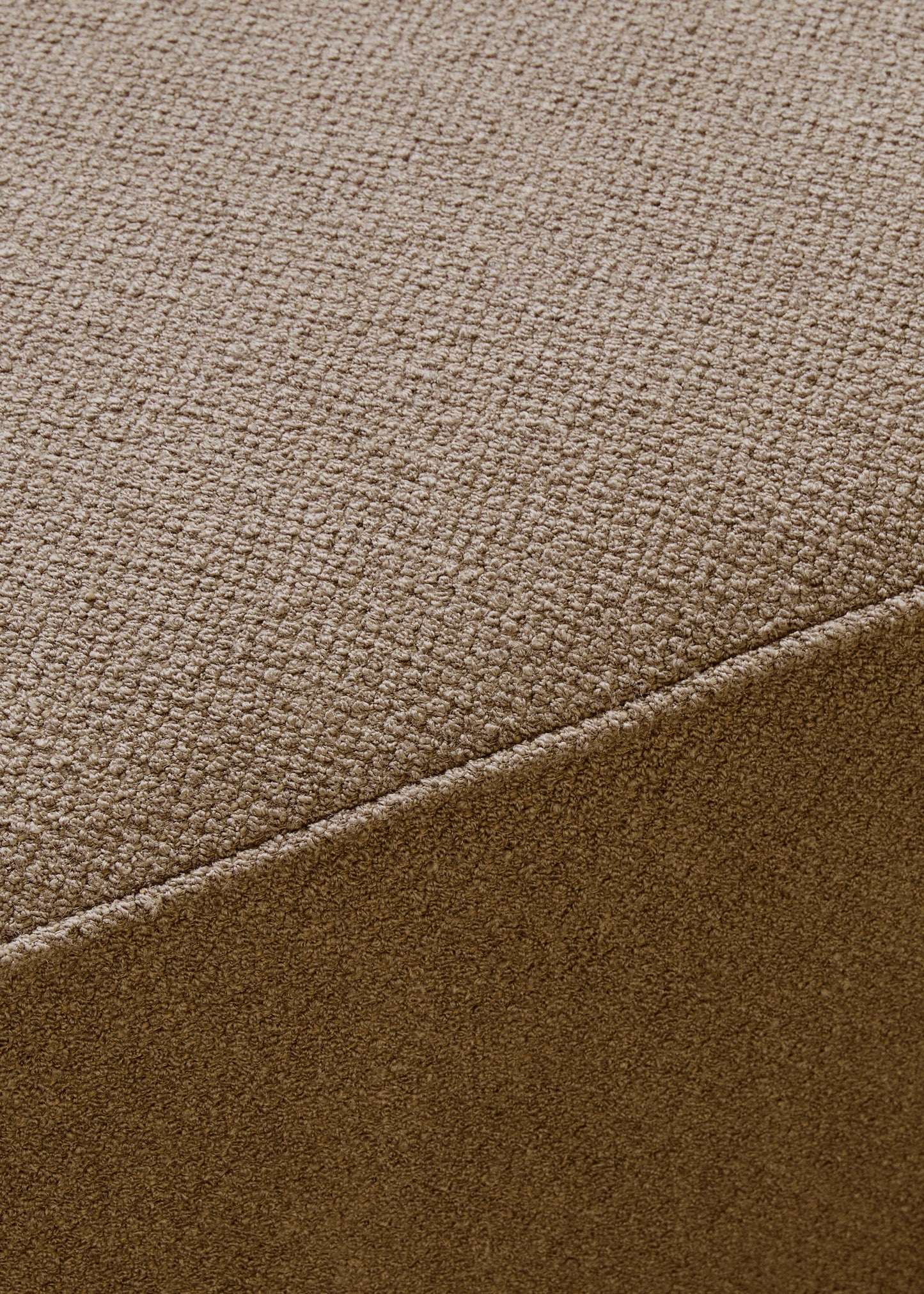 A detailed close-up of the textured brown bouclé fabric of the Eave Modular Sofa, 96, Pouf, showing a diagonal seam.