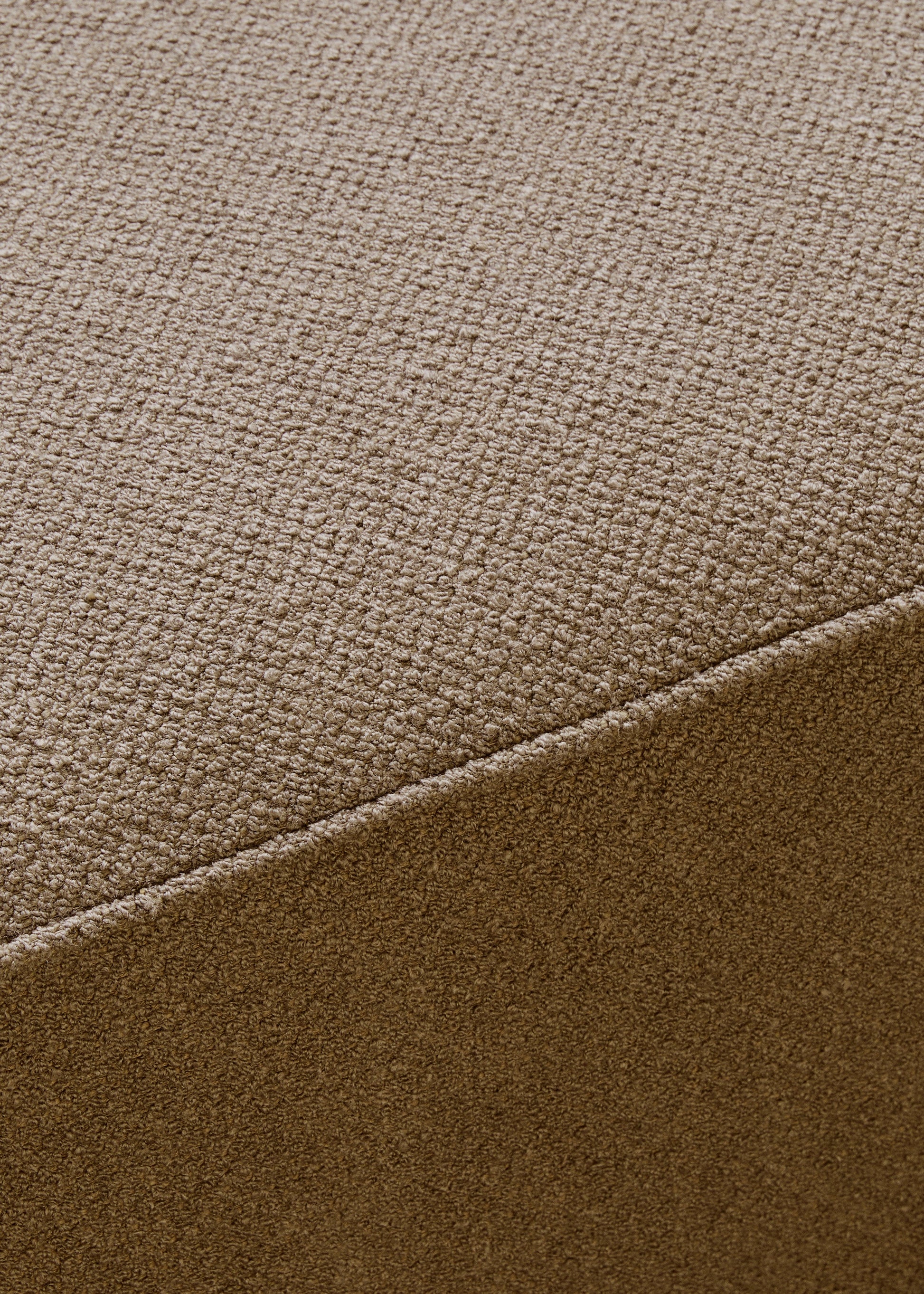 A close-up, angled shot of the Eave Modular Sofa, showcasing the rich texture and woven detail of its brown bouclé fabric.
