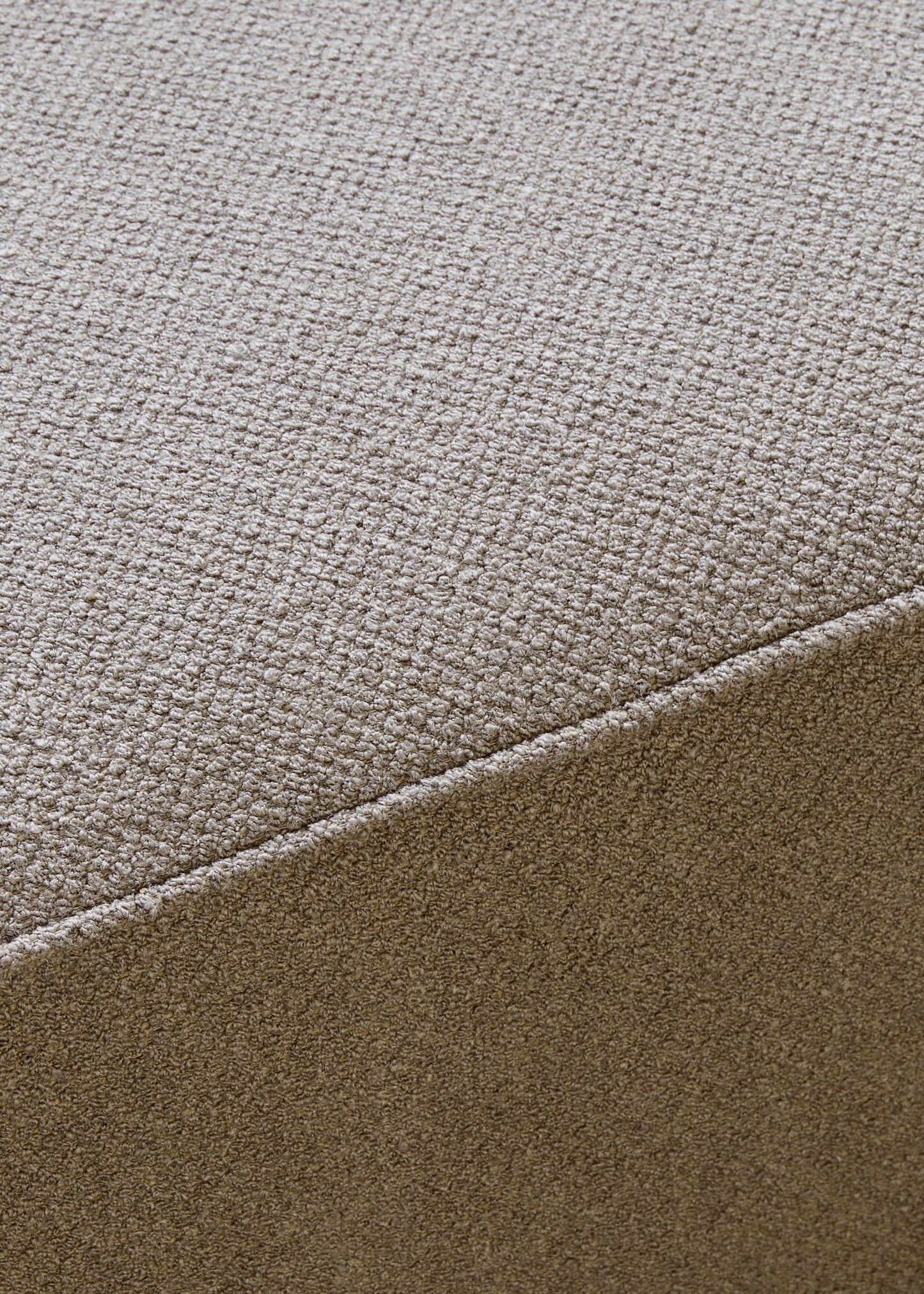 Close-up of the textured Audo Bouclé fabric in a light taupe colour, showing a seam detail on the Eave Modular Sofa Pouf.