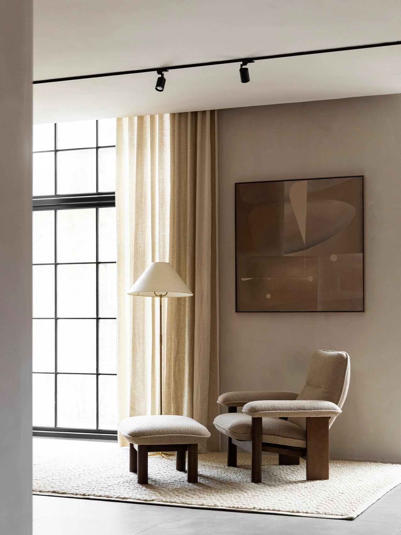 Brasilia Lounge Chair and Brasilia Ottoman on a Houkime Rug in a living room corner with a floor lamp and abstract art.