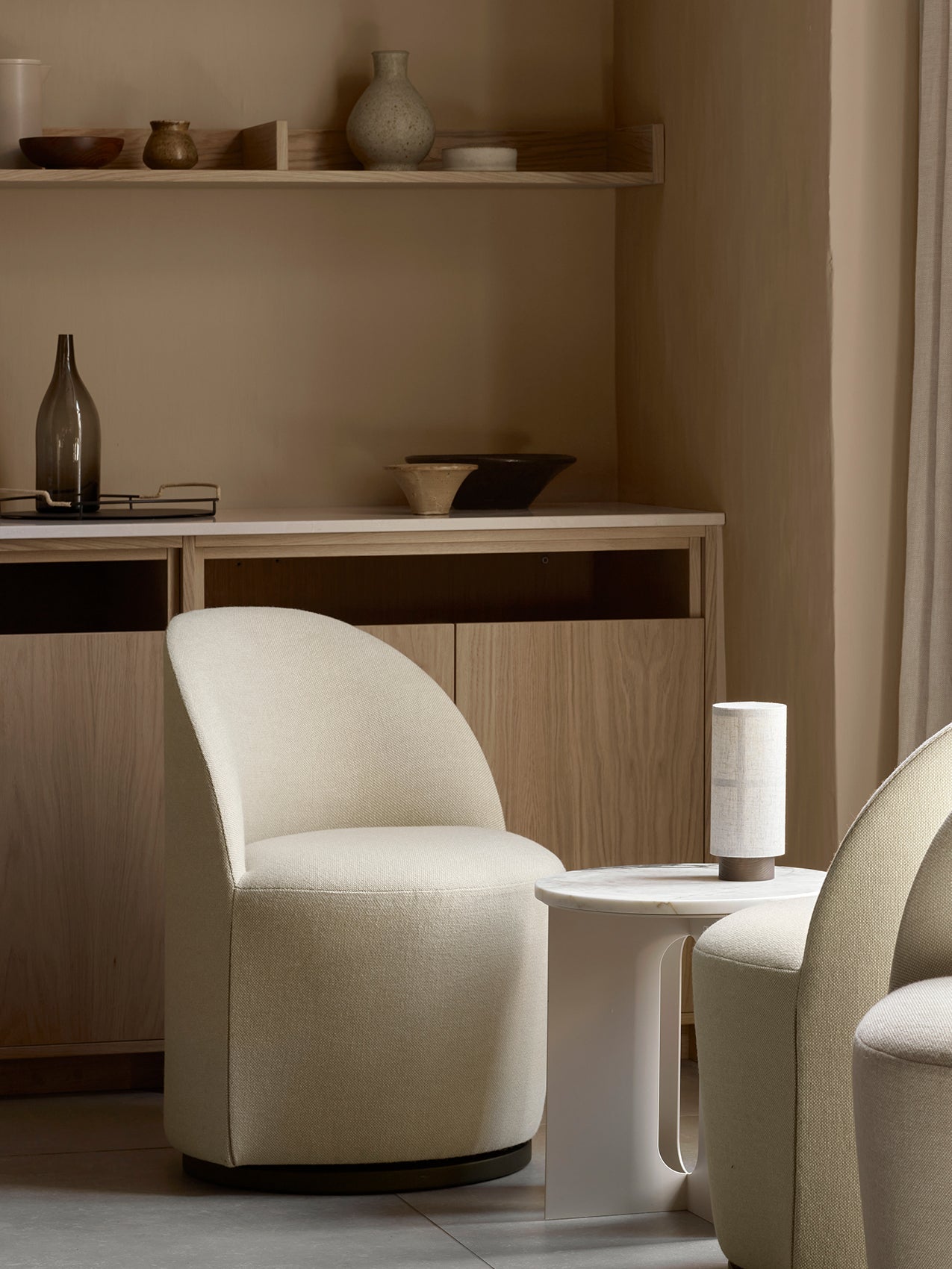 Tearoom Club Chair, Androgyne Side Table, and Hashira Table Lamp styled in a neutral-toned room with wooden cabinetry.