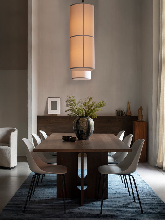 The lit Hashira Pendant Lamp illuminates an Androgyne Dining Table, Harbour Side chairs, and a blue Houkime Rug.
