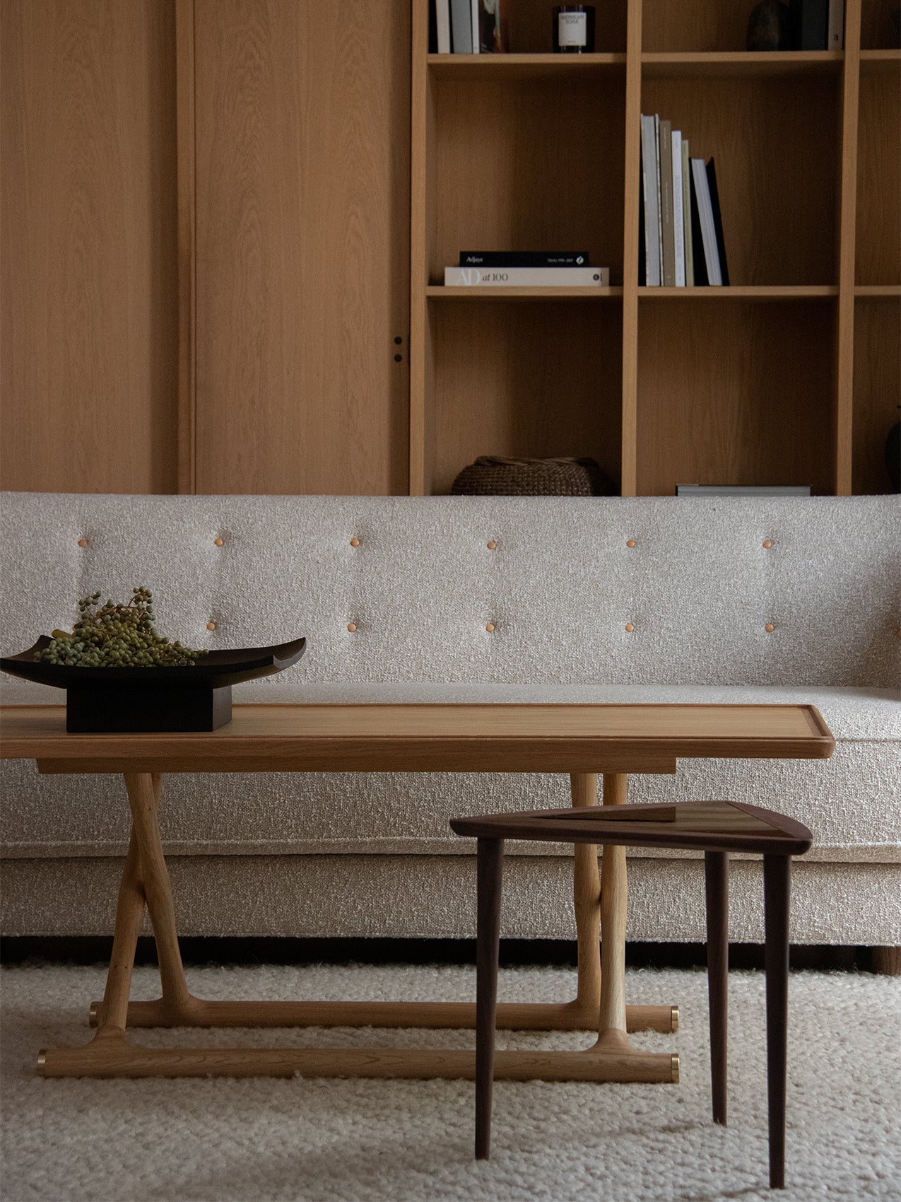 The Umanoff Nesting Side Table sits before a Vilhelm Sofa and Jager Lounge Table in a warm, wood-panelled living room.