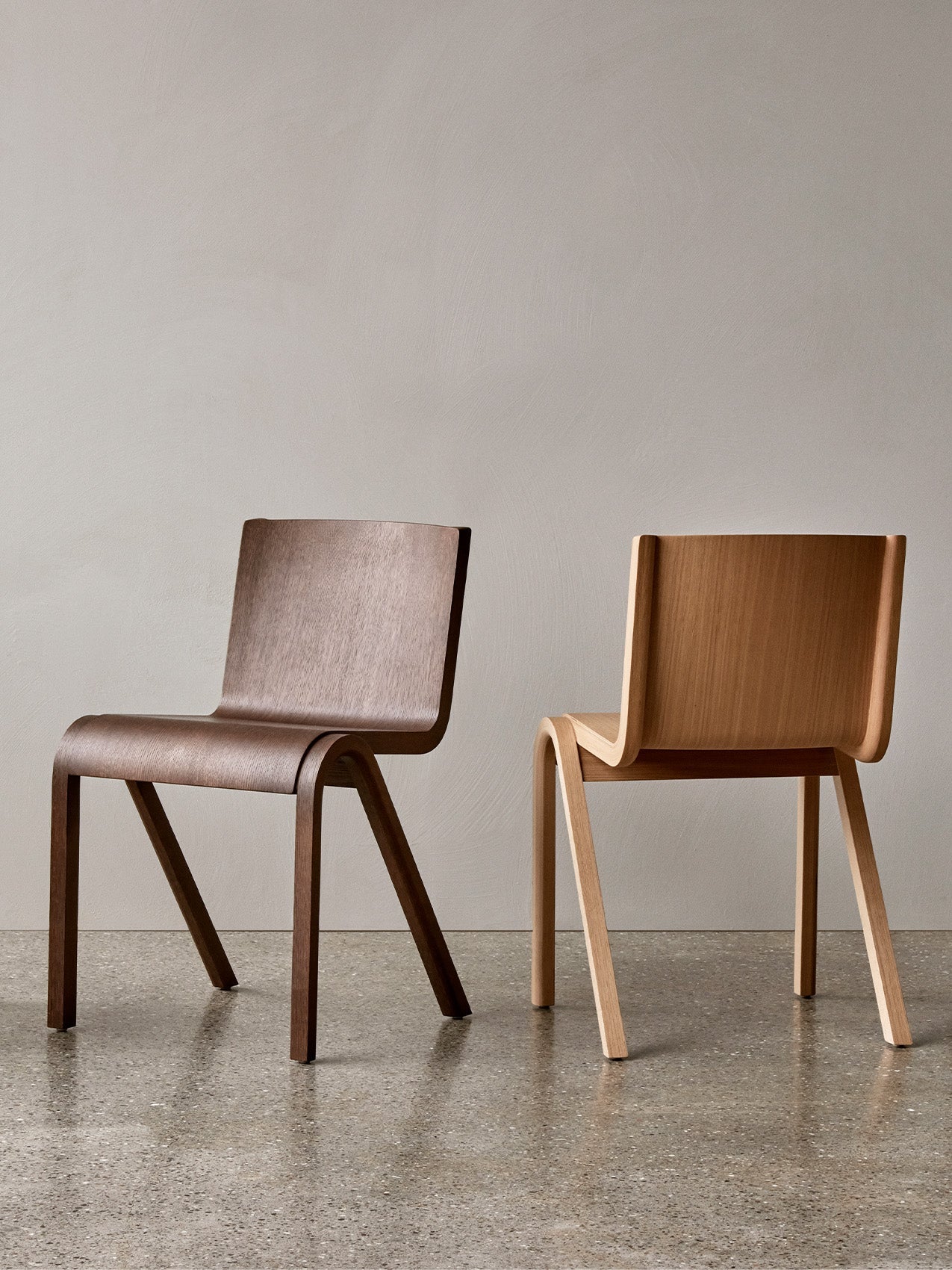 Two Ready Dining Chairs, one in a dark wood finish and one in a natural oak finish, shown side-by-side on a terrazzo floor.