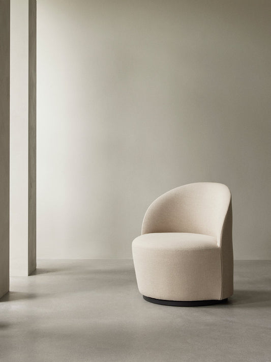 The cream bouclé Tearoom Lounge Chair, Swivel w/Return, sits in a minimalist room with a concrete floor and soft lighting.