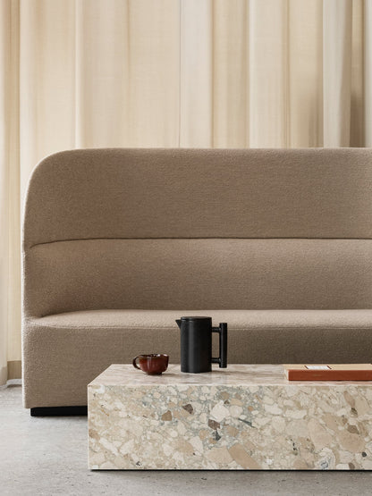 A beige Tearoom Sofa behind a terrazzo Plinth coffee table, styled with a black Yana Brewing Pot, a small cup, and a book.