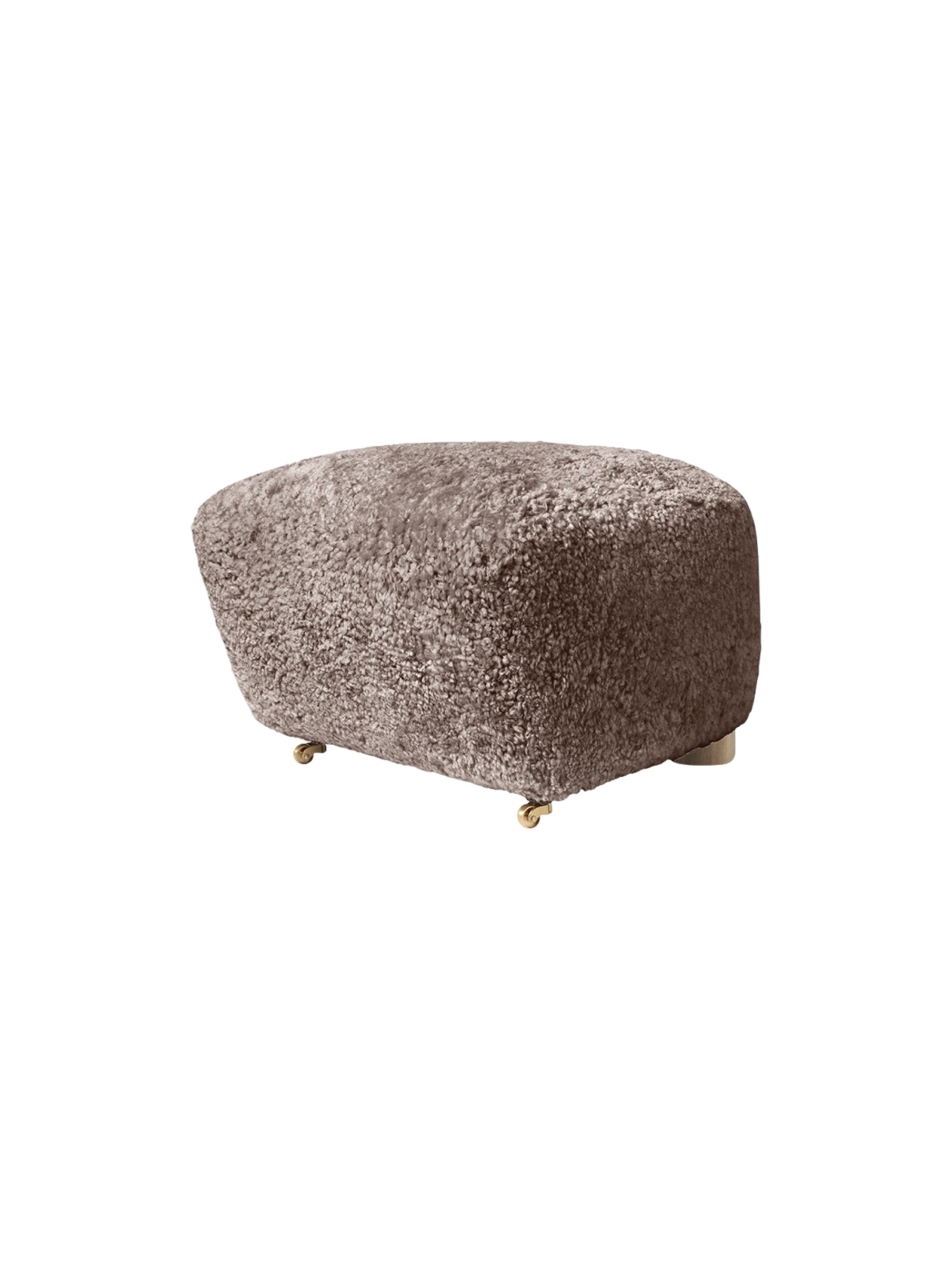 Three-quarter view of The Tired Man Ottoman in Sahara sheepskin, a fluffy footstool with short legs and front brass castors