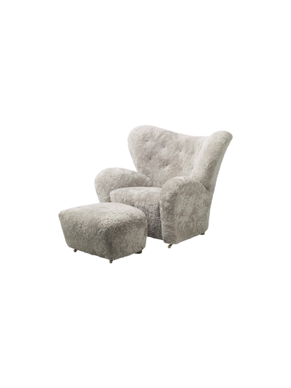 The Tired Man Ottoman, shown with the matching armchair. Both are upholstered in plush, green-tea coloured sheepskin.