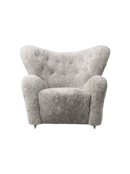 Front view of The Tired Man Lounge Chair in Green Tea sheepskin, showing its curved back and casters.