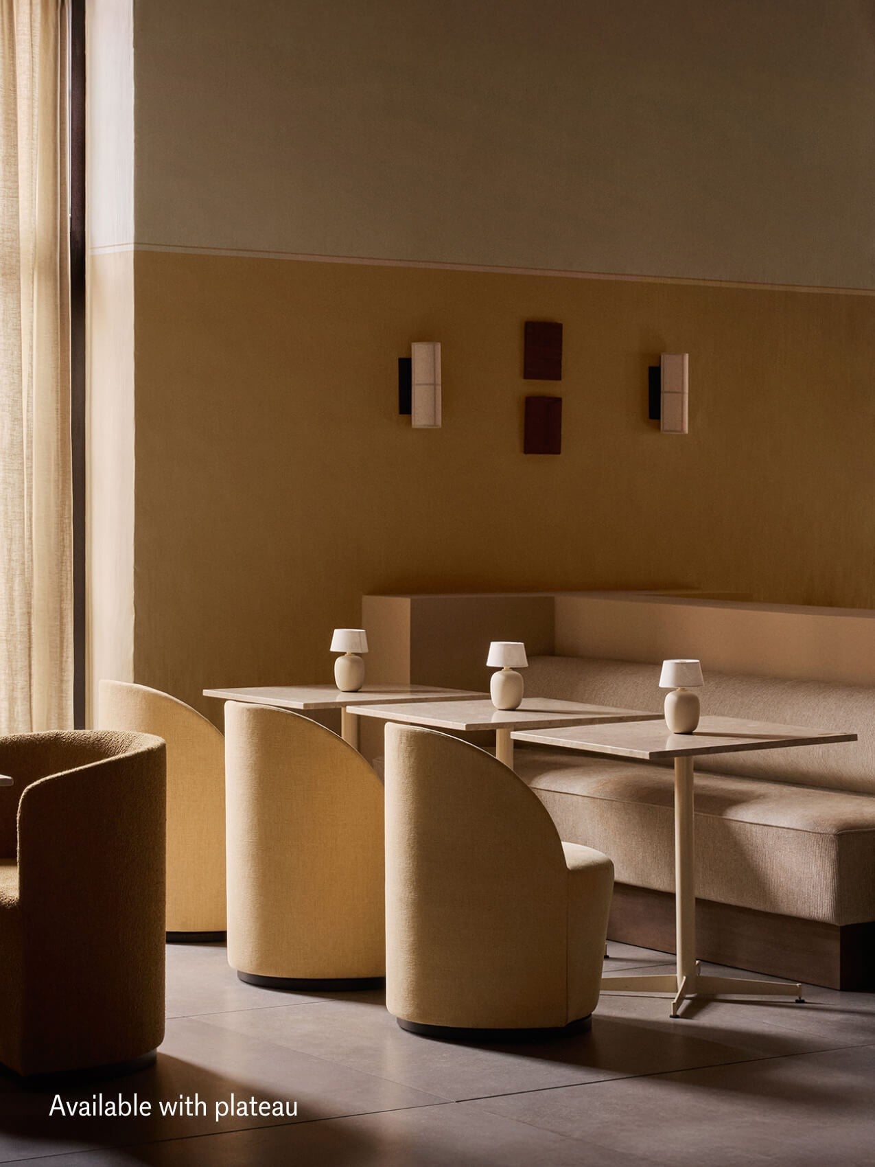 A row of tables in a restaurant setting featuring the beige Eave Dining Sofa with a high back plateau and yellow chairs.