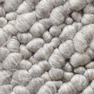 A close-up of the Gravel Grey fabric, showing the thick, nubby texture of its chunky, woven wool-like fibres.