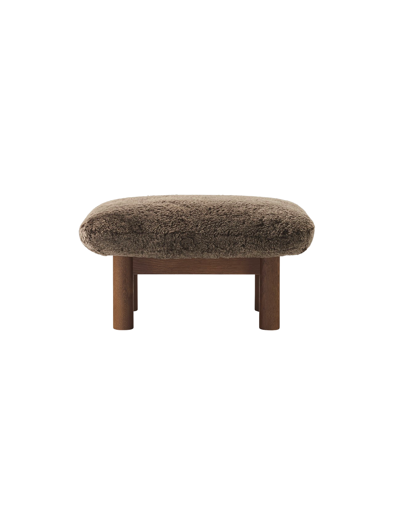 Front view of the Brasilia Ottoman in Sheepskin, with a dark stained oak frame and thick cylindrical legs.