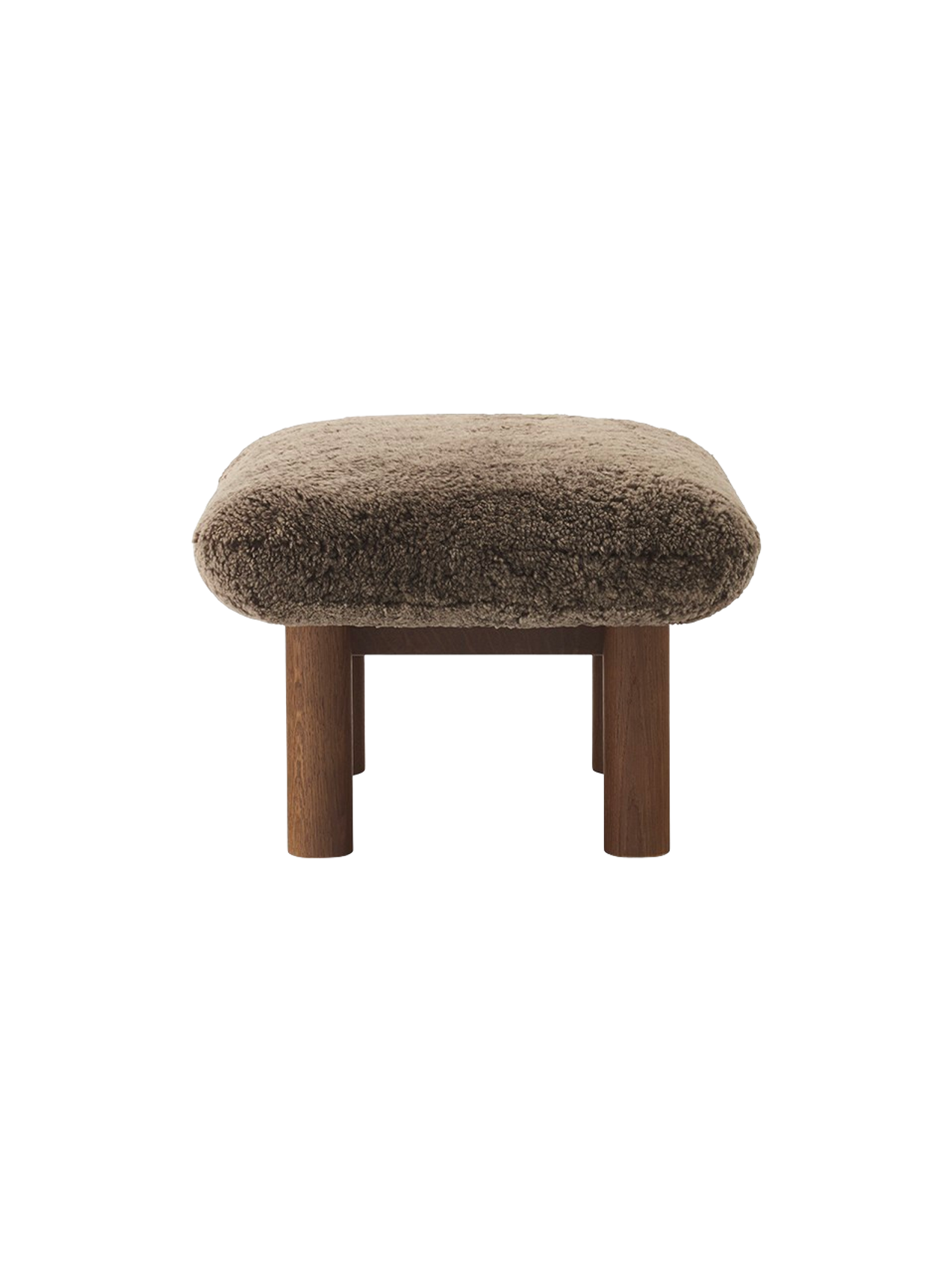 Side view of the Brasilia Ottoman in brown sheepskin, featuring a dark stained oak frame with four robust, cylindrical legs.