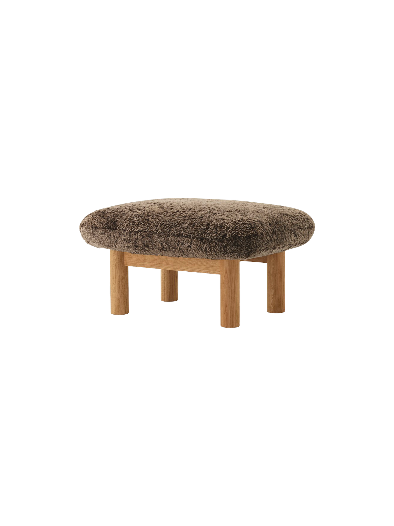 An angled shot of the Brasilia Ottoman, featuring a soft brown sheepskin cushion and natural oak frame with four round legs.